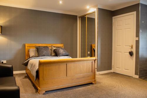 una camera con letto in legno e specchio di Forth Apartments a Kirkcaldy