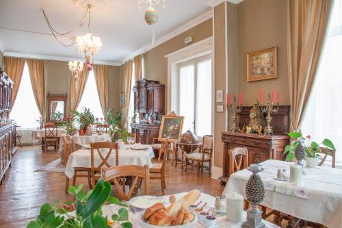 een eetkamer met tafels, stoelen en ramen bij Chateau de Moulin le Comte in Aire-sur-la-Lys