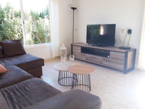 a living room with a couch and a tv and a table at Casa La Rana in Calafat