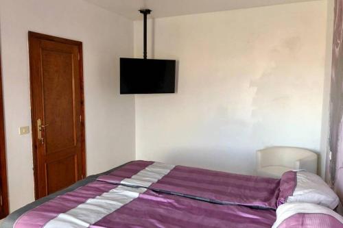 a bedroom with a bed with a purple blanket at Casa con piscina privada. Mirador de Humbolt. in Santa Úrsula