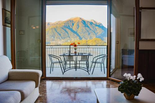 a room with a table and chairs and a view of a mountain at Bellagio Villas in Lezzeno