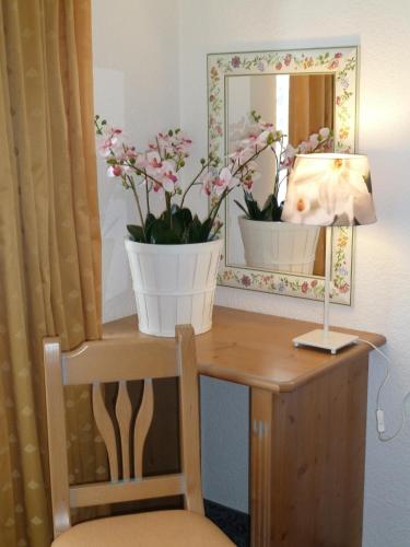 a desk with a lamp and a vase with flowers on it at Appartement Gurgl in Obergurgl