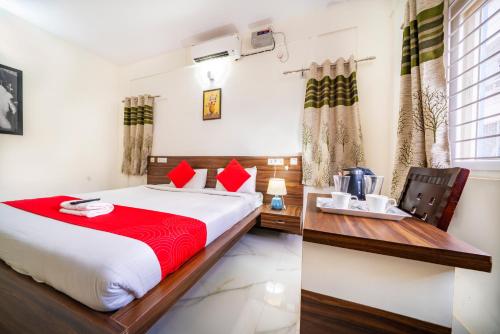 een slaapkamer met een bed en een tafel met een koffiezetapparaat bij Sports Icon Suites in Yelahanka
