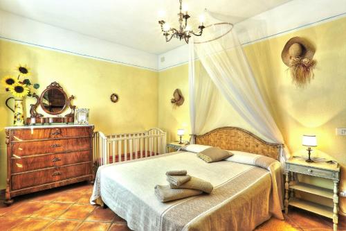 1 dormitorio con cama, tocador y espejo en Appartamento Girasole - Agriturismo le Selvole, en Pomarance