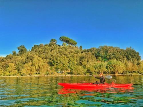 een persoon in een rode kajak in het water bij International Glamping Lago Di Bracciano in Trevignano Romano