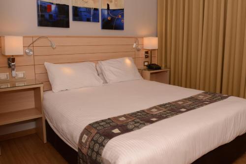 a hotel room with a bed and a desk at Crystal Suites in Amman