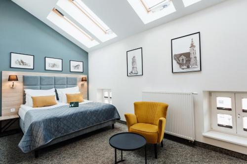 a bedroom with a bed and a chair at Hotel 32 Krak&oacute;w Old Town in Krakow
