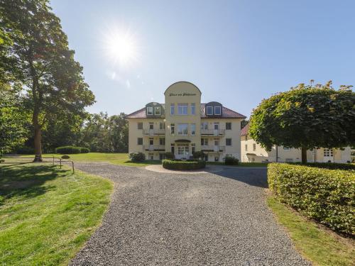 une grande maison avec une allée en gravier dans l'établissement Ferienwohnungen im Haus am Kölpinsee, à Waren