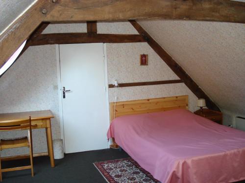 a bedroom with a bed and a desk in a attic at Gite de Cohignac in Berric
