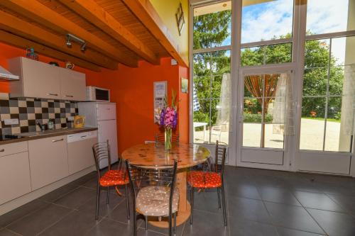 une cuisine avec une table et des chaises dans une cuisine dans l'établissement gîtes de l'Hôpiteau, à LʼOie