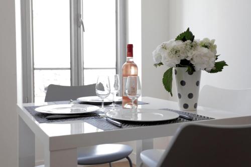 une table avec une bouteille de vin et un vase de fleurs dans l'établissement C004-Cosy studio proche la Croisette et le Suquet, à Cannes