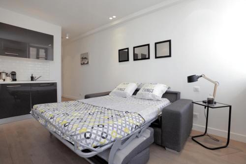 - une chambre avec un lit et une lampe dans l'établissement C004-Cosy studio proche la Croisette et le Suquet, à Cannes