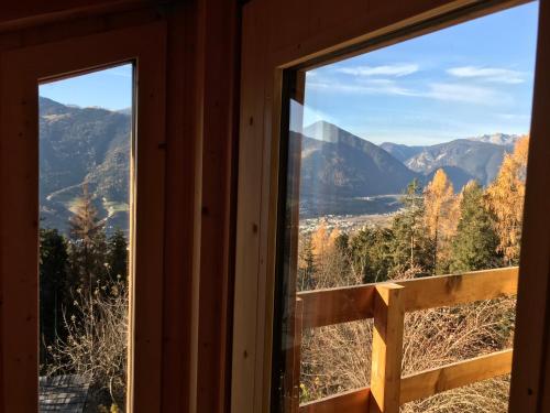 a window in a cabin looking out at the mountains at Haus Lasaun in Bressanone