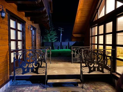 a set of chairs on a porch at night at Hostynnyy Dvir Apartament Hotel & SPA in Slavske