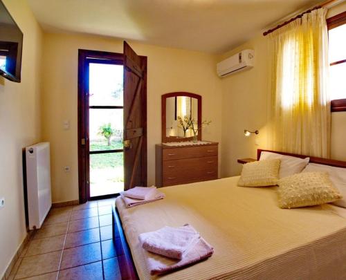 Arménoi的住宿－Villa Maragoudi，一间卧室配有一张带镜子的床和窗户
