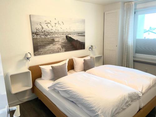 um quarto com uma cama com pássaros a voar por cima em Sola-Bona-Wohnung-29 em Westerland