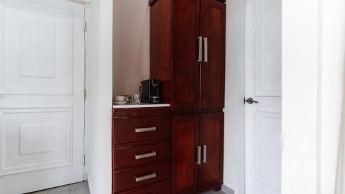 a large wooden cabinet in a kitchen with a microwave at Casa Wilson Inn in San Juan