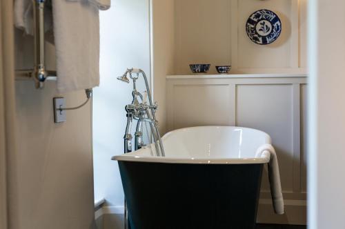 a bathroom with a bath tub in a room at Grove of Narberth in Narberth