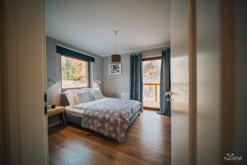 sypialnia z łóżkiem i oknem w obiekcie Apartament Viki & Ski w Szklarskiej Porębie