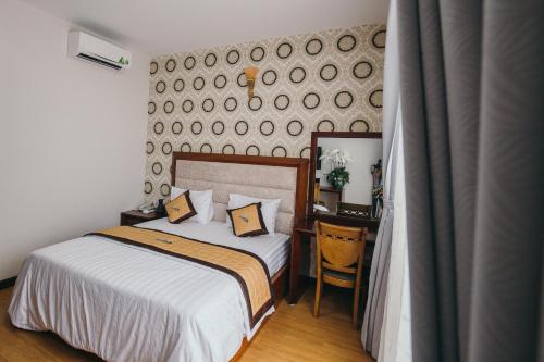 a bedroom with a bed and a desk and a mirror at BLUE STAR HOTEL in Tây Ninh