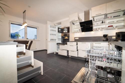 een grote keuken met witte kasten en apparaten bij Lindes Appartement in Umhausen