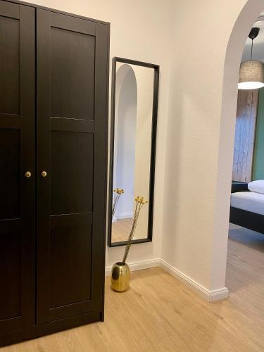 a bedroom with a black cabinet and a mirror at Landgasthaus Löwen mit Gästehaus in Holzhausen
