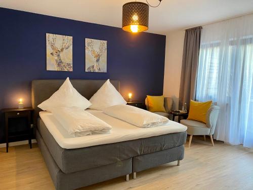 een slaapkamer met een groot bed en een blauwe muur bij Landgasthaus Löwen mit Gästehaus in Holzhausen
