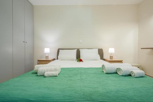 a bedroom with a large white bed with a green rug at Ampeloessa Village in Kornós