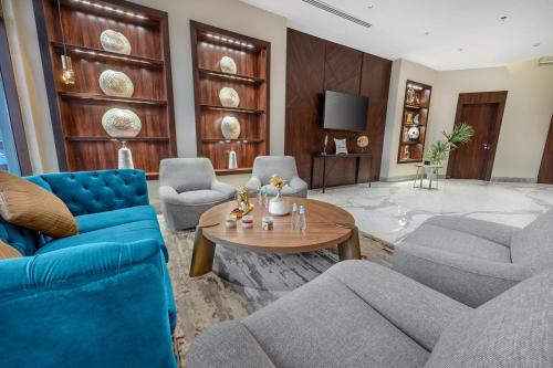 a living room with blue chairs and a table at Suknai Royal Hotel in Hail