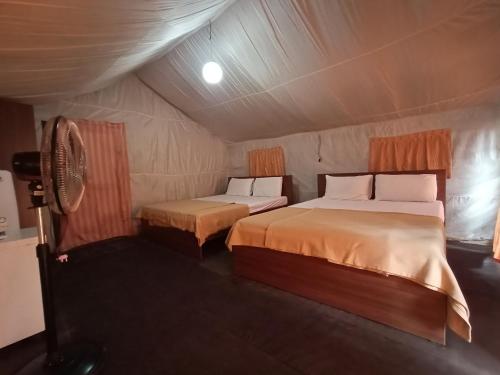a bedroom with two beds in a tent at KABINI FARM STAY in Antarasante