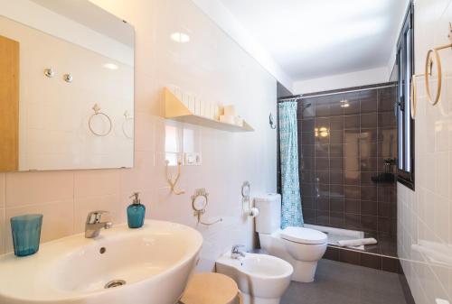 a white bathroom with a sink and a toilet at El Granado Hostel in Granada