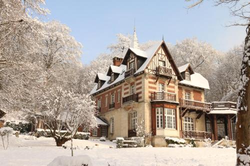 a large house with snow on it in the yard at Villa du Châtelet in Choisy-au-Bac