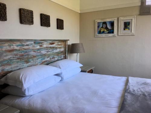 烏姆科馬斯的住宿－Kingfisher Cottage，一间卧室配有带白色床单和枕头的床。