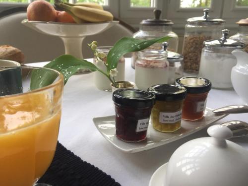 une table avec des bocaux de confiture et une assiette de nourriture dans l'établissement Villa du Châtelet, à Choisy-au-Bac