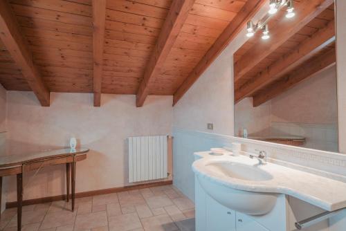 a bathroom with a white sink and wooden ceilings at Villa Natalina - a 100 metri dalle Terme Virgilio in Sirmione