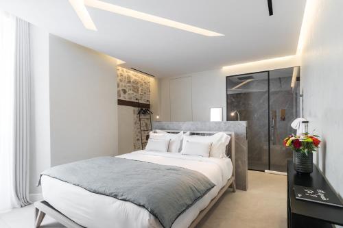 a bedroom with a large white bed and a desk at Le Dortoir Boutique Suites in Nice