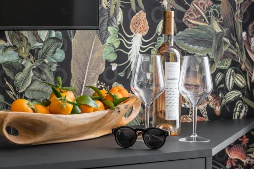 a bowl of fruit and a bottle of wine and glasses at Le Dortoir Boutique Suites in Nice