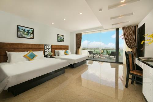 a hotel room with two beds and a balcony at Tuan Chau Kingly Villa in Ha Long