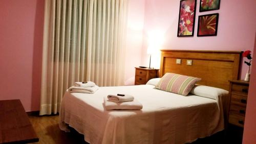 1 dormitorio con 1 cama con toallas en posada trastamara en Piedralaves
