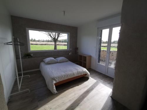 1 dormitorio con cama y ventana grande en Le pigeonnier de La Mouline en Viterbe
