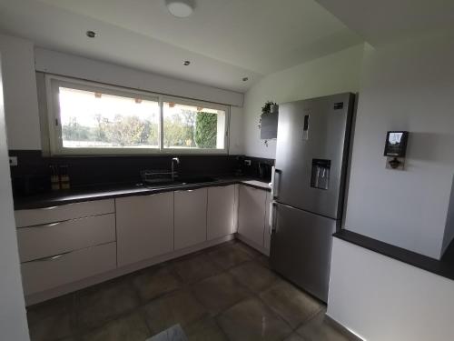 Il comprend une cuisine équipée d'un réfrigérateur et d'une fenêtre. dans l'établissement Le pigeonnier de La Mouline, à Viterbe