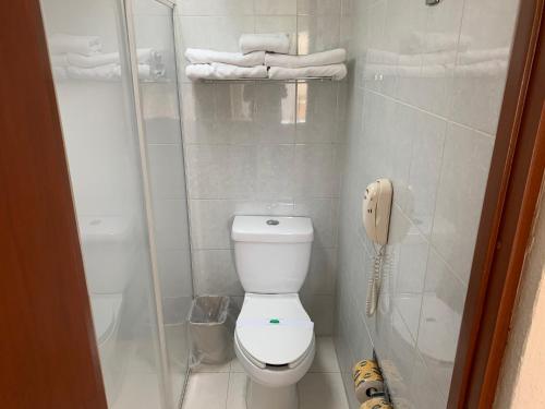 a small bathroom with a toilet and a phone at Hotel Villa Florida Córdoba in Córdoba