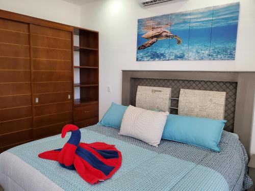 a red and blue towel sitting on top of a bed at Riviera Maya Luxury Oceanfront Condo in Akumal