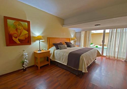 a bedroom with a bed and a painting on the wall at Hotel Villa Florida Córdoba in Córdoba
