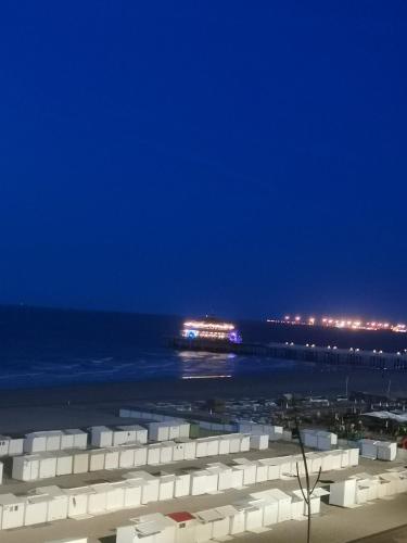 a beach at night with a pier in the distance at studionusi in Blankenberge