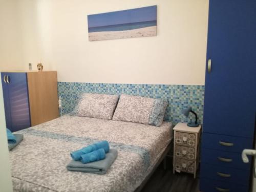 - une petite chambre avec un lit et une armoire bleue dans l'établissement TRISCINA SUMMER HOUSE, à Triscina