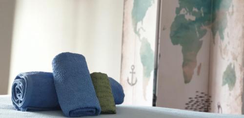three rolls of blue and green towels sitting on a shelf at Casa Compartida Weyler in Santa Cruz de Tenerife