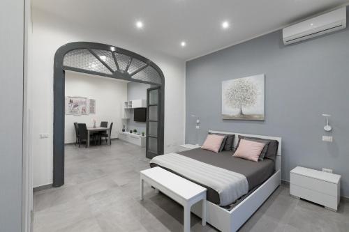 a bedroom with a bed and a room with a table at Dante Square in Naples