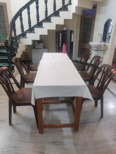 a dining room table with a white table cloth on it at jayaram Home in Chittoor