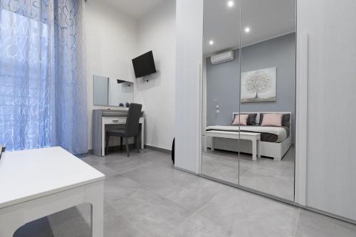 Zimmer mit einem Bett, einem Schreibtisch und einem Spiegel in der Unterkunft Dante Square in Neapel